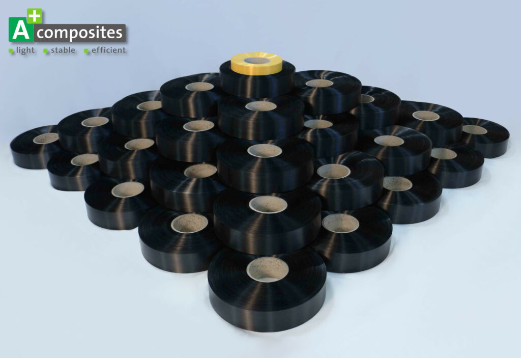 Six layers of UD-Tapes spools form a pyramide. All are black except of the one on the top which is yellow